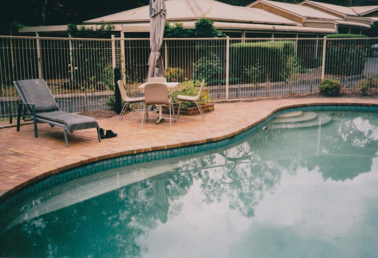 Pool fence install showing code-compliant vertical-bar aluminum